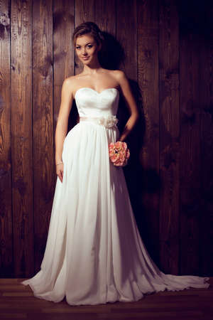 fashion studio photo of beautiful tender bride in elegant lace wedding dress with wedding bouquetの写真素材