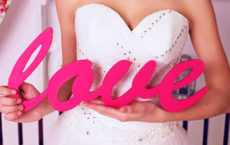 fashion studio photo of bride in elegant lace wedding dress holding deco loveの写真素材