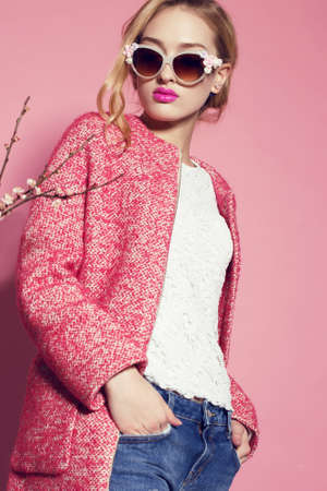 fashion studio photo of gorgeous young woman with blond curly hair wears elegant pink coat,blouse...