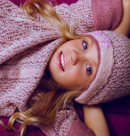 fashion studio foto of cute blond little girl  lying on purple poufの写真素材