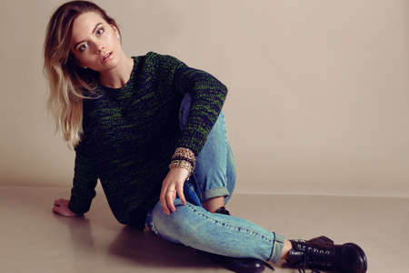 fashion studio photo of beautiful young girl with blond hair wears casual clothes,cardigan,jeans and...