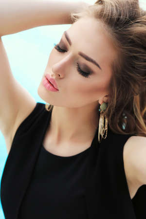 fashion outdoor photo of gorgeous sexy woman with blond curly hair in elegant clothes posing outdoorの写真素材