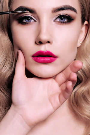 fashion studio portrait of gorgeous young woman with blond hair, making make upの写真素材