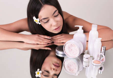 fashion interior photo of beautiful woman with dark hair and natural look, using cosmetics