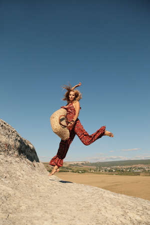 fashion photo of beautiful woman with blond hair in elegant clothes posing outdoorの写真素材