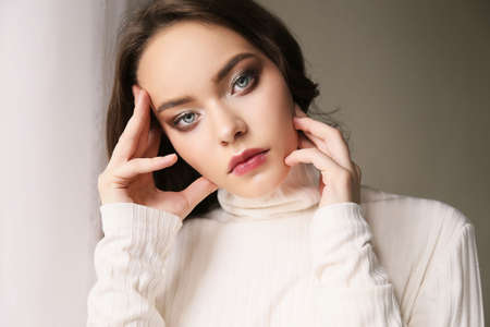 fashion photo of beautiful young woman with natural hair and makeup, in casual clothes ,posing in studioの写真素材