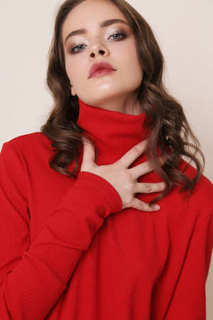 fashion photo of beautiful young woman with natural hair and makeup, in casual clothes ,posing in studioの写真素材