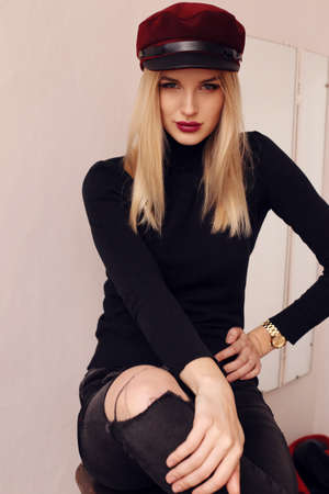 fashion photo of beautiful girl with blond hair in elegant clothes and hat posing in studioの写真素材