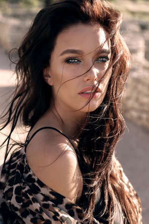 fashion outdoor photo of beautiful sexy woman with dark hair in elegant swimming suit relaxing on summer beachの写真素材