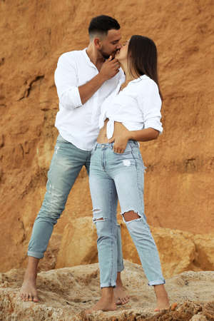 fashion outdoor photo of beautiful lovely couple wearing jeans,posing at summer beachの写真素材
