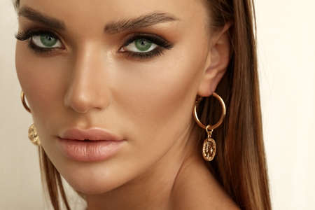 fashion portrait of beautiful woman with dark hair with accessories posing in studio