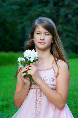 Young girl in pink dress with white flowersの写真素材