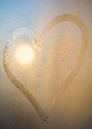 Heart from dew drops on the window surface in the eveningの写真素材