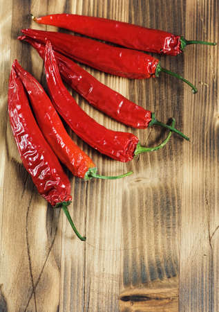 Dried red hot chili peppers on the wooden background