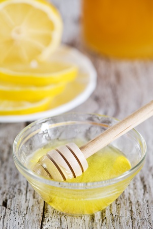 Wooden dipper with honey and lemonsの写真素材