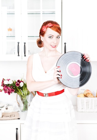 Beautiful woman with red hair holding vinyl recordの写真素材