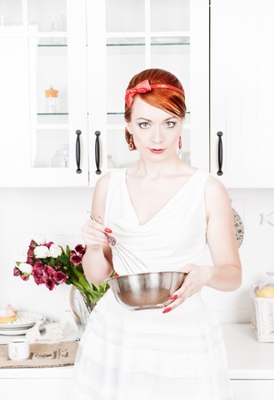 Beautiful housewife with utensils  on the kitchenの写真素材