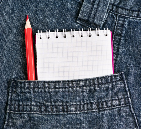Notebook and red pencil in jeans pocketの写真素材