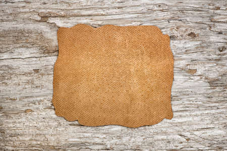 Piece of leather on the old wooden backgroundの写真素材