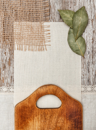 Canvas, burlap and linen fabric with cutting board on the old wooden backgroundの写真素材