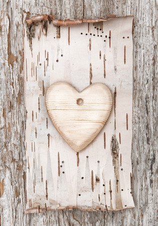 Wooden heart with birch bark on the old wooden backgroundの写真素材