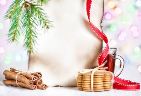 Christmas card with tea, cookies, cinnamon and abstract bokeh backgroundの写真素材