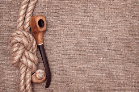 Ship rope, seashells and tobacco pipe on hessianの写真素材