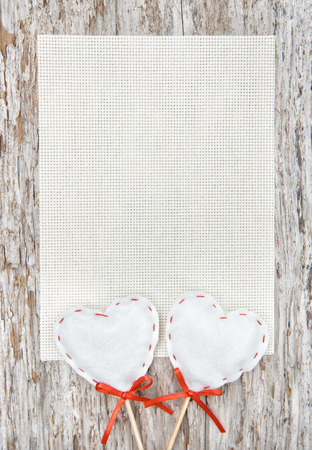 Valentine card with textile hearts on old wood backgroundの写真素材