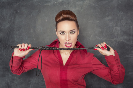 Beautiful fashion woman in the red blouse with whip in her hands