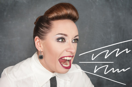 Angry screaming woman on the blackboard backgroundの写真素材