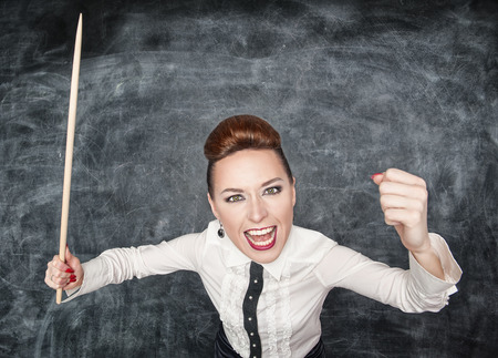 Angry screaming teacher with pointer in her handの写真素材