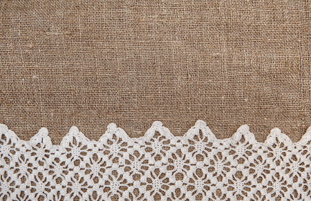 Burlap textile background with white lacy clothの写真素材