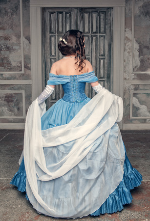 Beautiful medieval woman in long blue dress, back Beautiful medieval woman in long blue dress, back