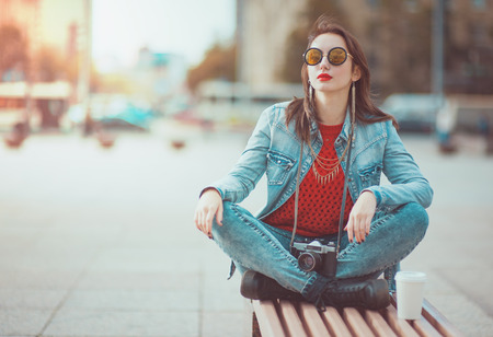 Young beautiful hipster girl with retro camera in the cityの写真素材