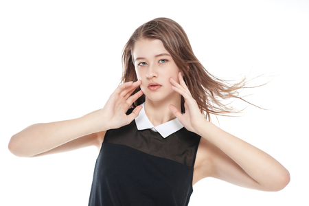 Young beautiful teenager girl with fluttering hair isolated on white backgroundの写真素材