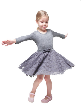 Beautiful little girl spinning around isolated over white backgroundの写真素材