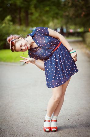 Happy beautiful young girl in fifties style with braces outdoorの写真素材
