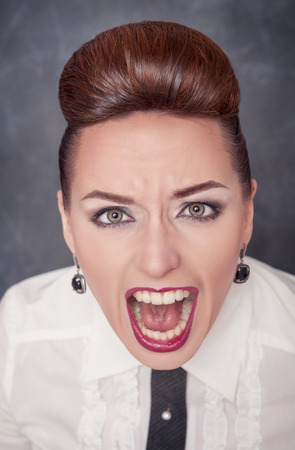 Angry screaming woman on the blackboard backgroundの写真素材