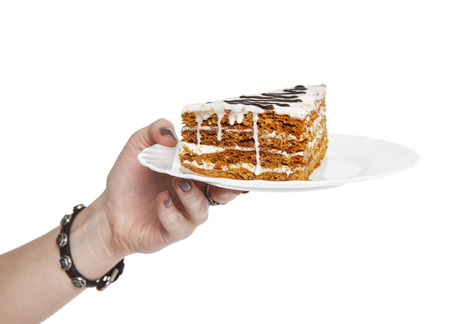 Hand holding piece of cake isolated on white backgroundの写真素材