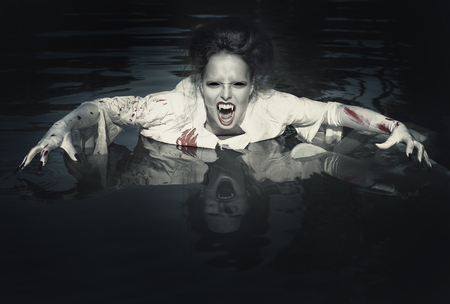 Terrible demon in the bloody shirt standing in the riverの写真素材