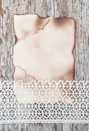 Lace fabric and aged paper on the old wooden backgroundの写真素材