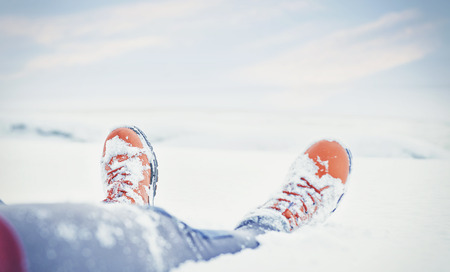 Legs of traveler sitting in deep snow outdoor. Travel and discovery conceptの写真素材