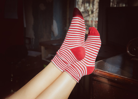 Woman feet in red socks with sunlight. Relax concept