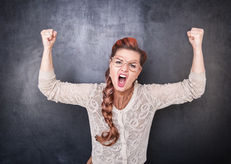 Angry screaming teacher on chalkboard blackboard backgroundの写真素材