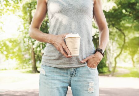 Woman holding empty paper coffee cup outdoor. Template mock upの写真素材