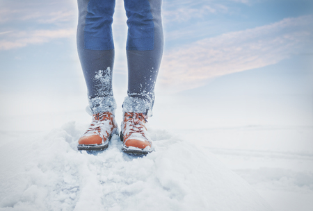 Legs of traveler standing in deep snow outdoor. Travel and discovery conceptの写真素材