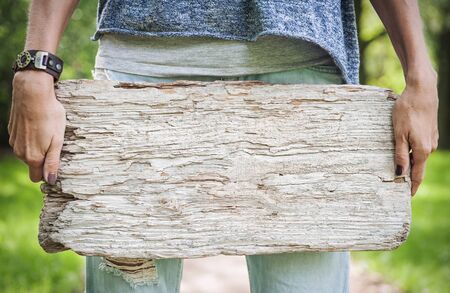 Woman holding empty wooden board outdoor. Template mock up