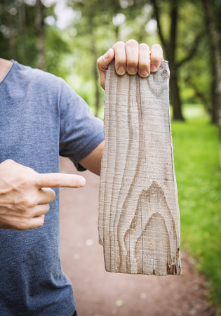 Man holding empty wooden board outdoor. Template mock upの写真素材