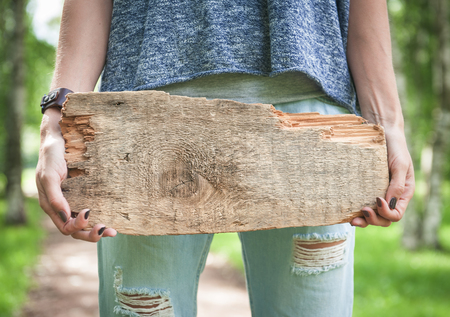Empty wooden board hold by woman hand outdoor. Template mock upの写真素材