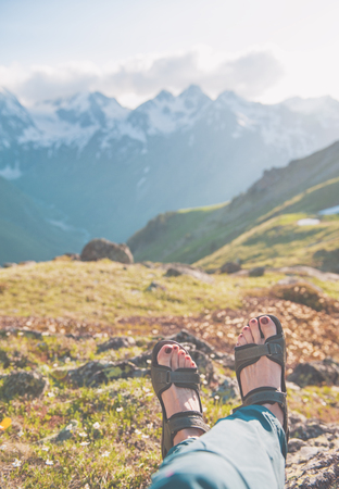 Legs of traveler sitting on top of mountain outdoor. Travel conceptの写真素材